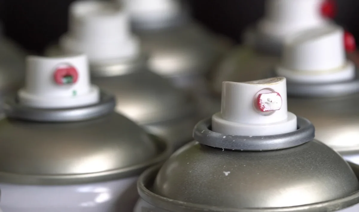 A close view of aerosol spray cans and their nozzles.
