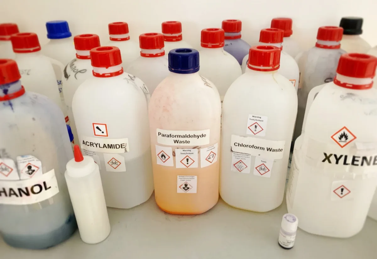 Labelled chemical-waste bottles in a laboratory.