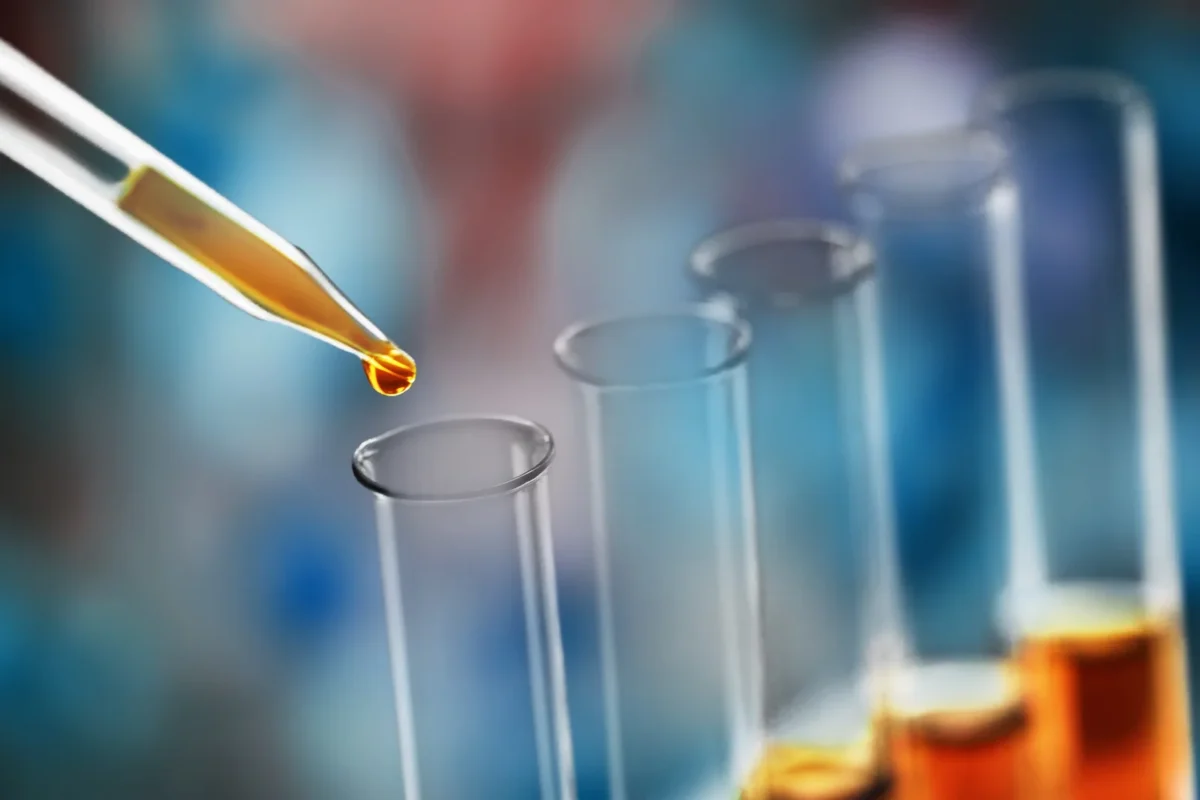 Laboratory pipette transferring an oil sample into a glass tube.